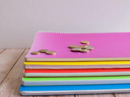 group of notebooks with money on top of them