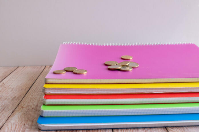 group of notebooks with money on top of them
