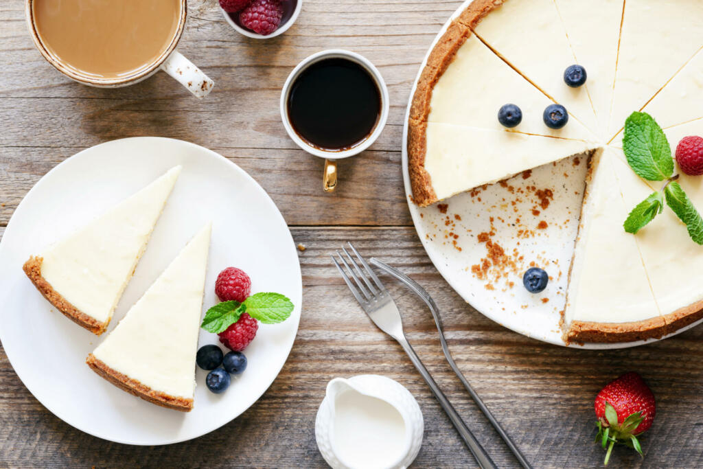 Homemade classical New York cheesecake and coffee on wooden table. Top view