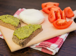 Italian Style Breakfast Pesto Sauce, Mozzarella Cheese And Tomatoes Served on A Wodden Platter