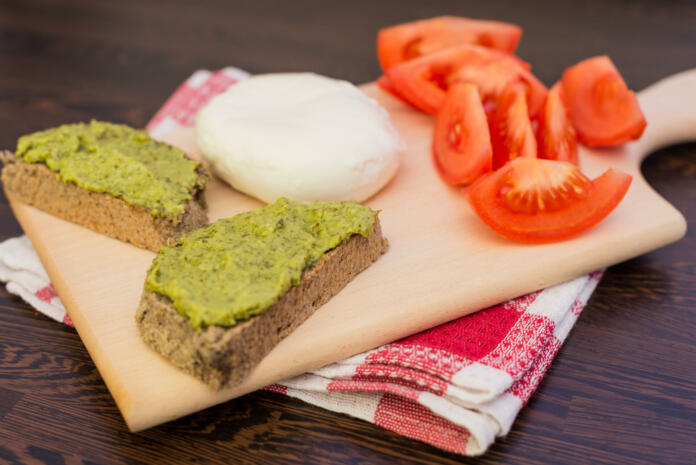 Italian Style Breakfast Pesto Sauce, Mozzarella Cheese And Tomatoes Served on A Wodden Platter