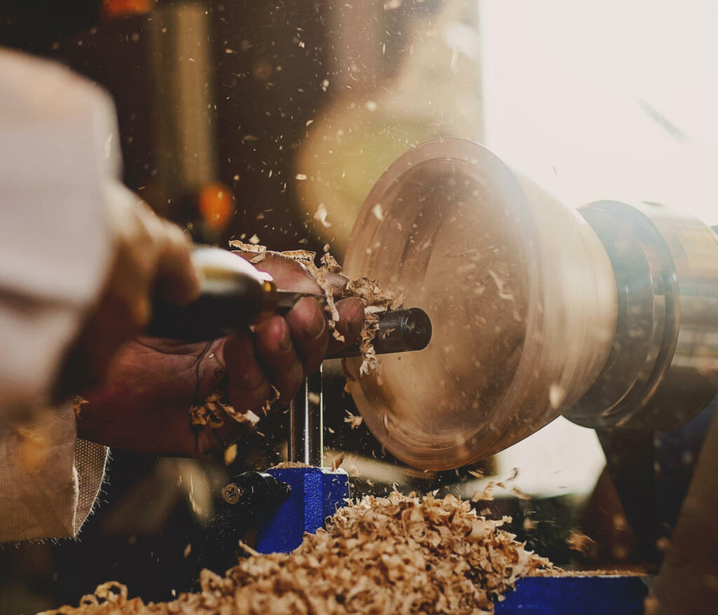 Man using a woodturning lathe to make a wooden bowl