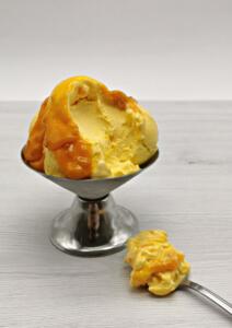 Sladoled v skodelici in žlica polna sladoleda poleg