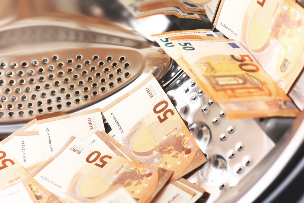 Money laundering symbol, 50 euro banknotes inside washing machine. Tax evasion. Illegal financial transactions. Euro currency.