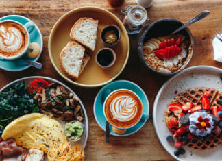 Top 5 idej za brunch v Ljubljani Morning breakfast on a table above, waffles with cream, berries, coffee, cappuccino, bowl, omlet with vegetables, bread with butter, avocado cream, vegan food, healthy food, meal.