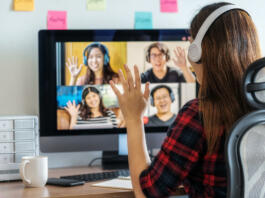 Online meeting, Social distancing and new normal concept, Rear View of Asian Business woman say hello with teamwork colleague in video conference when Coronavirus outbreak