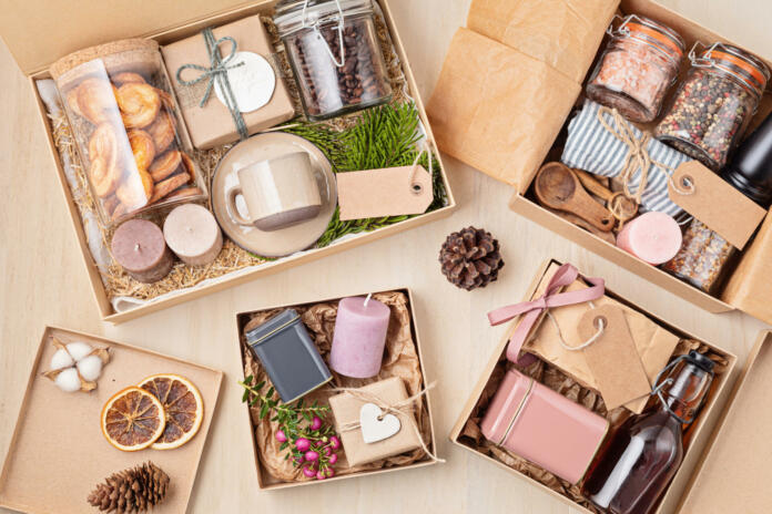 Preparing care package, seasonal gift box with coffee, cookies, candles, spices and cups. Personalized eco friendly basket for family and friends for thankgiving, christmas, mothers and fathers day holidays.