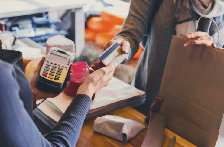 Retail, credit card payment service. Customer paying for order of cheese in grocery shop.