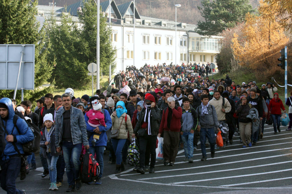 Sintilj, Slovenia - November 19, 2015:  A group of refugees and migrants walk from the Slovenian to the Austrian transit camp on the border.  Countries along the Balkan refugee route, including Slovenia, are now restricting entry to refugees who can prove they are from Syria, Afghanistan, or Iraq.