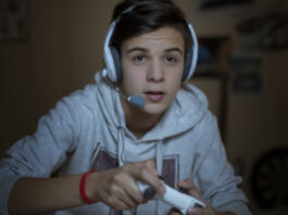 Teenage boy with headset playing video game