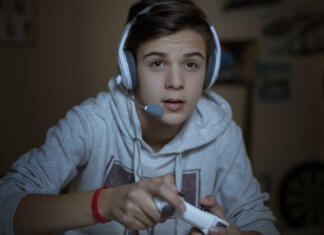 Tudi ti igraš te priljubljene videoigre? Teenage boy with headset playing video game