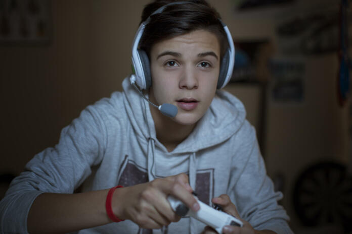 Teenage boy with headset playing video game