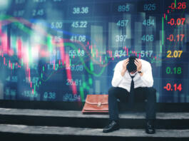 Tired or stressed businessman sitting on the walkway in panic digital stock market financial background