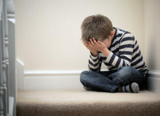 Slovenija je dobila drugi krizni center za otroke Upset problem child with head in hands sitting on staircase concept for childhood bullying, depression stress or frustration