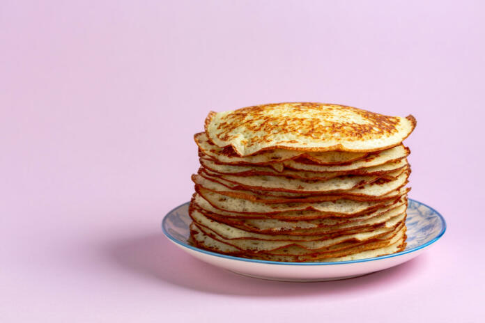 Yeast pancakes on a plate, copy space. Concept of the traditional dish of the Russian Maslenitsa week (Maslenitsa).