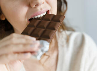 Bolj zdrava vrsta čokolade na vidiku, pravi znanost Ženska, ki je ugriznila v čokolado.