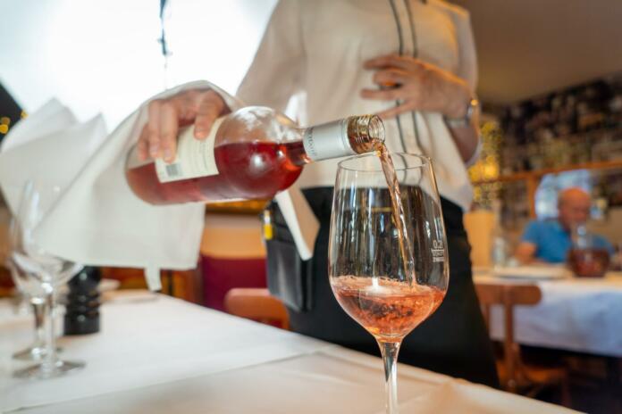 a bottle of rose wine being served in a restaurant.