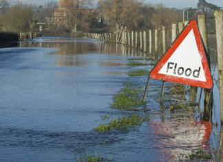 Poplavna varnost v Sloveniji: Kakšne so prepreke in uspehi? A flood warning sign, on a closed country road next to water logged fields in the Avon Valley, Hampshire, England. Flooded after an extreme amount of rainfall at the start of 2014