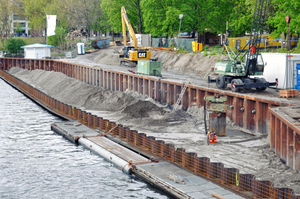 Berlin, Germany - April 15, 2017: The process of construction of the embankment. Installation of metal formwork and mound. Excavators in the background.