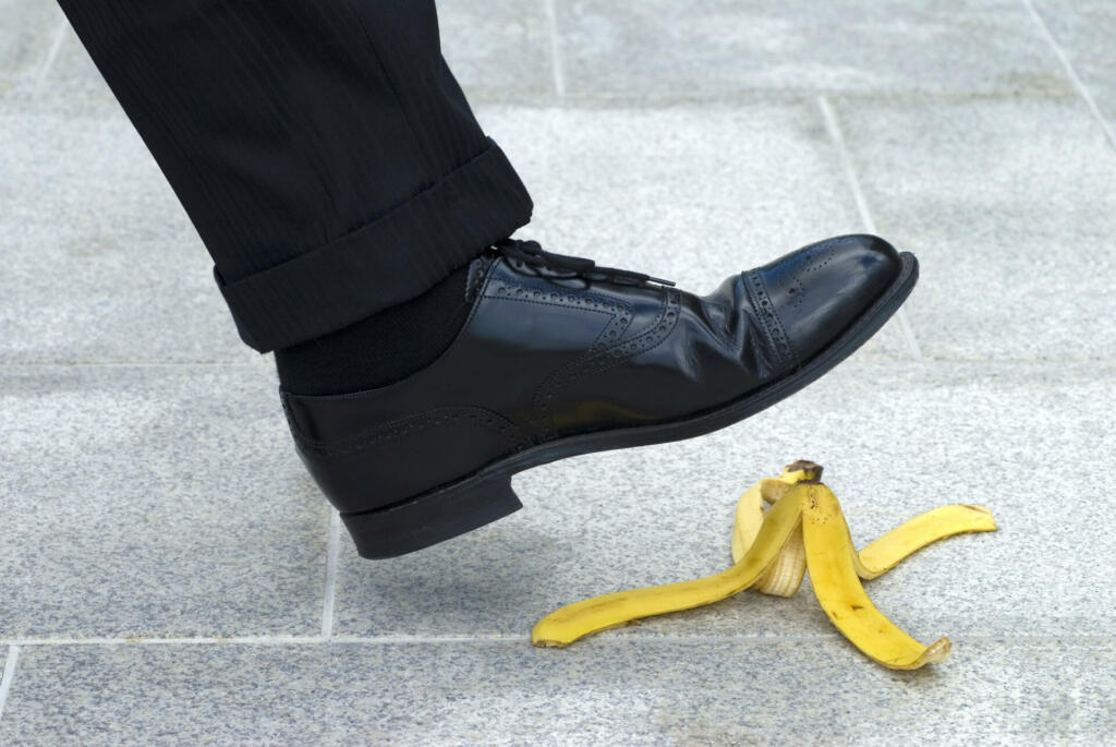 Businessman stepping on banana skin