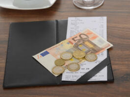 Close-up Of Bill With Euro Note On Wooden Table