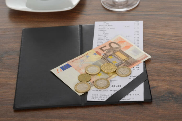 Close-up Of Bill With Euro Note On Wooden Table