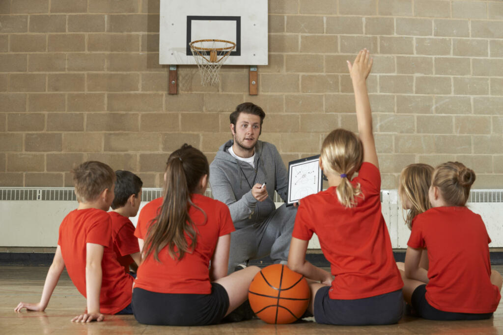 Coach Giving Team Talk To Elementary School Basketball Team