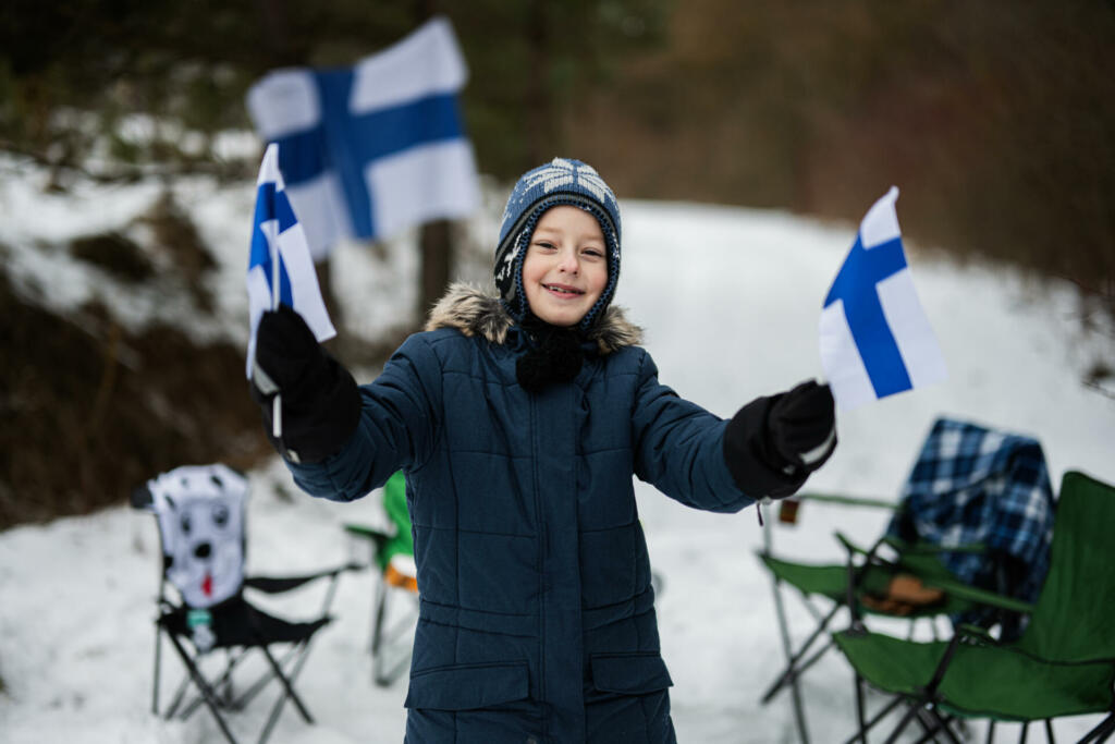 Finnish boy with Finland flags on a nice winter day. Nordic Scandinavian people.