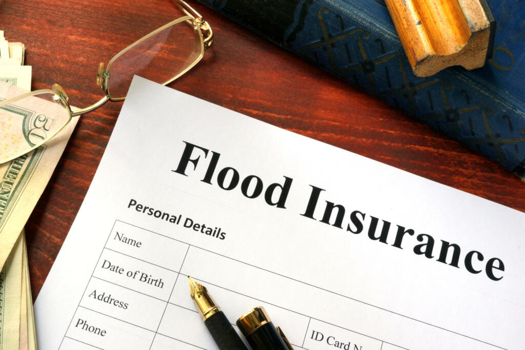 Flood insurance form on a table with a book.