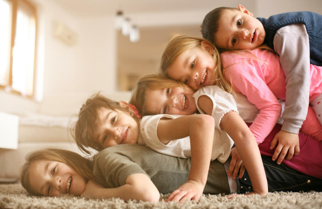 Large group of children lying at floor and having fun. Looking at camera.