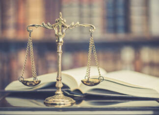 Katere spremembe Ustave so res potrebne in kako reformirati slovenski visokošolski pravni okvir? Legal office of lawyers, justice and law concept : Judge gavel or a hammer and a base used by a judge person on a desk in a courtroom with blurred weight scale of justice, bookshelf background behind.