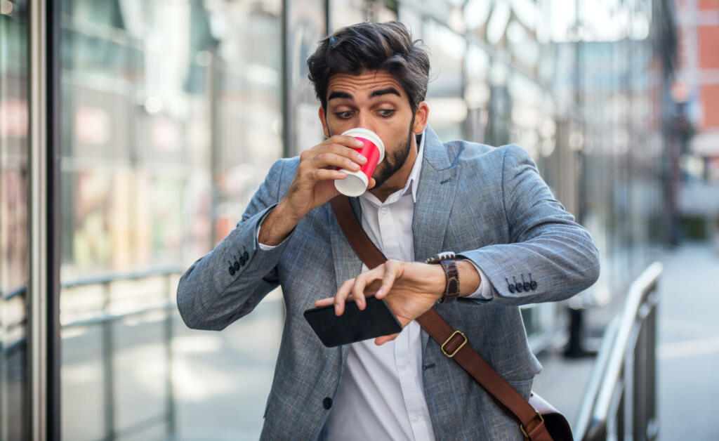 Never don't be late on business meeting. Worried businessman looking at his watch on the way to office. Business, lifestyle concept