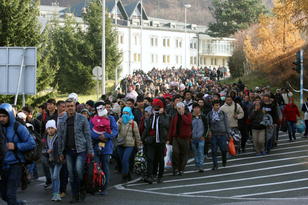 Sintilj, Slovenia - November 19, 2015: A group of refugees and migrants walk from the Slovenian to the Austrian transit camp on the border. Countries along the Balkan refugee route, including Slovenia, are now restricting entry to refugees who can prove they are from Syria, Afghanistan, or Iraq.