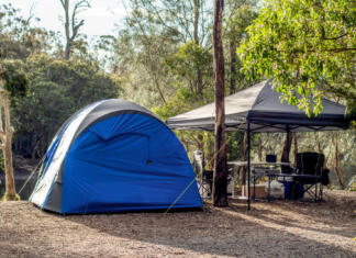 Kje v Sloveniji lahko kampiraš? Tent setup with gazebo canopy shelter at the campsite surrounding by nature on the river bank. Camping and recreation