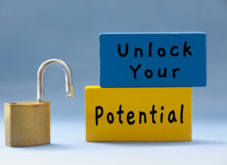 Projekt Start up your dreams – zakaj so sanje pomembne (Erasmus+) Unlock your potential text on wooden blocks with pad lock on light blue background. Motivational concept