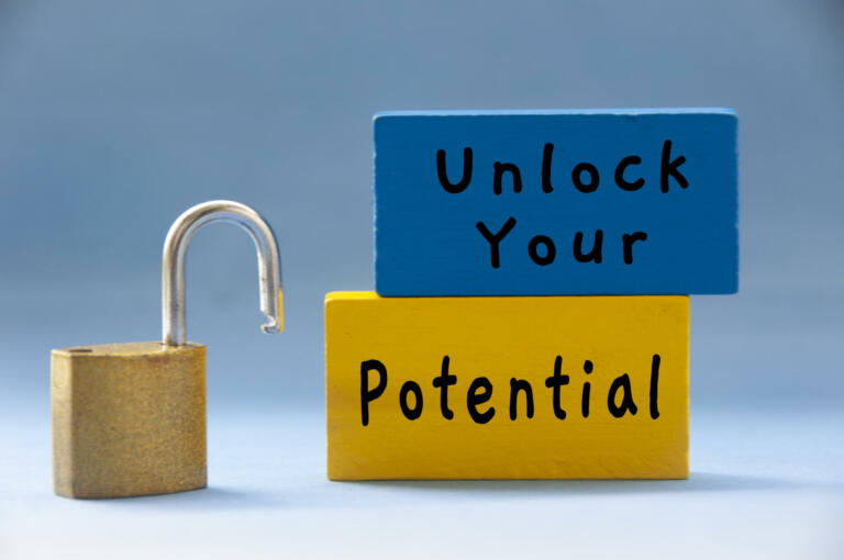 Unlock your potential text on wooden blocks with pad lock on light blue background. Motivational concept