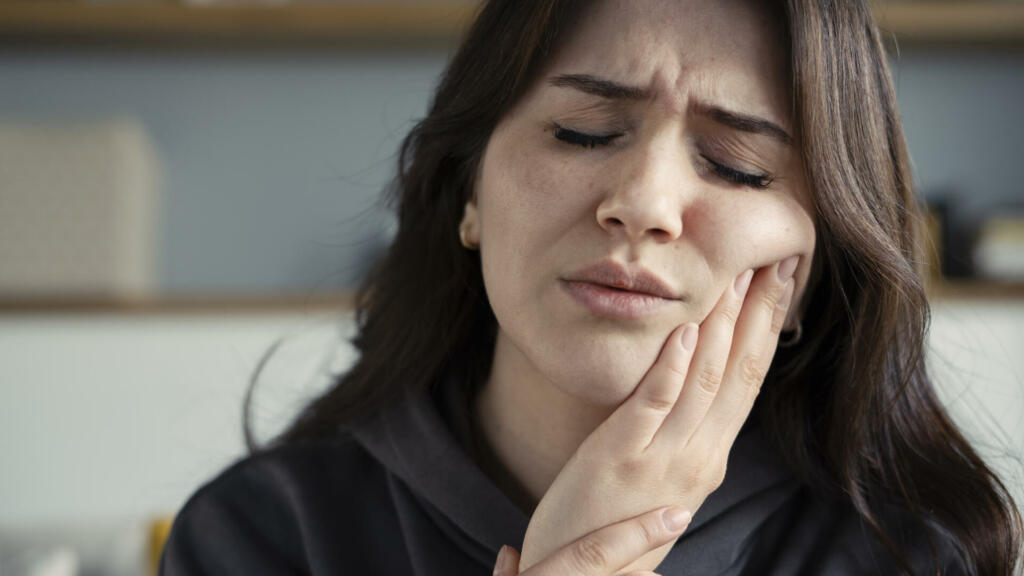Woman suffering toothache at home