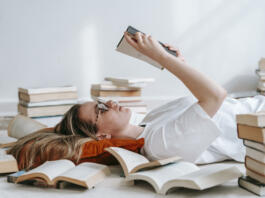 Young smart woman reading book on floor