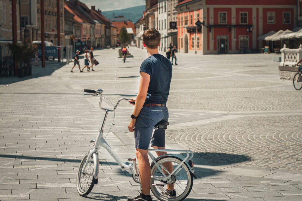 Moški s kolesom v mestu