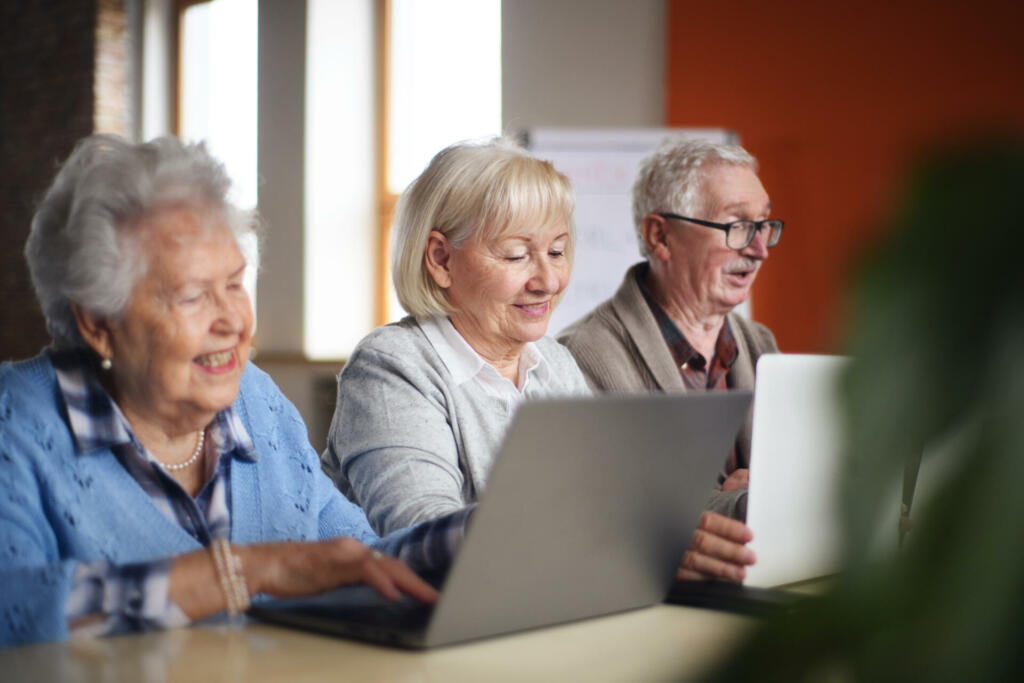 A senior group in retirement home learning together in computer class