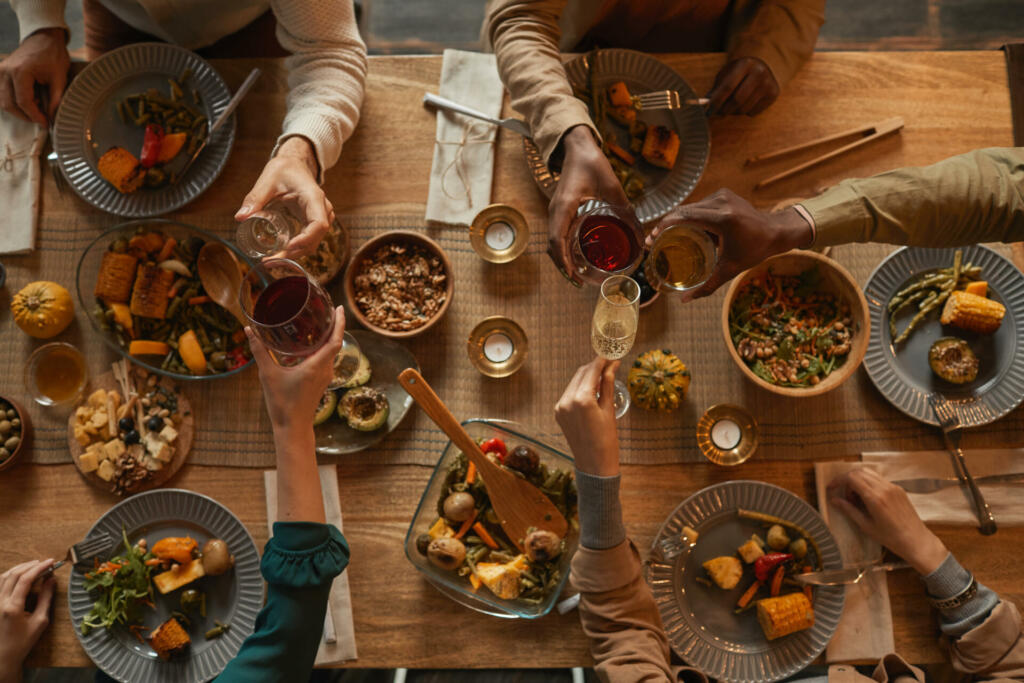 Above view background of multi-ethnic group of people enjoying feast during dinner party with friends and family