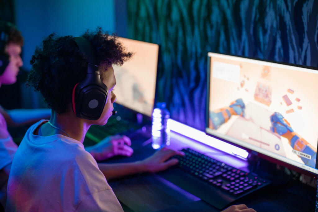 Boy with black headphones playing computer game