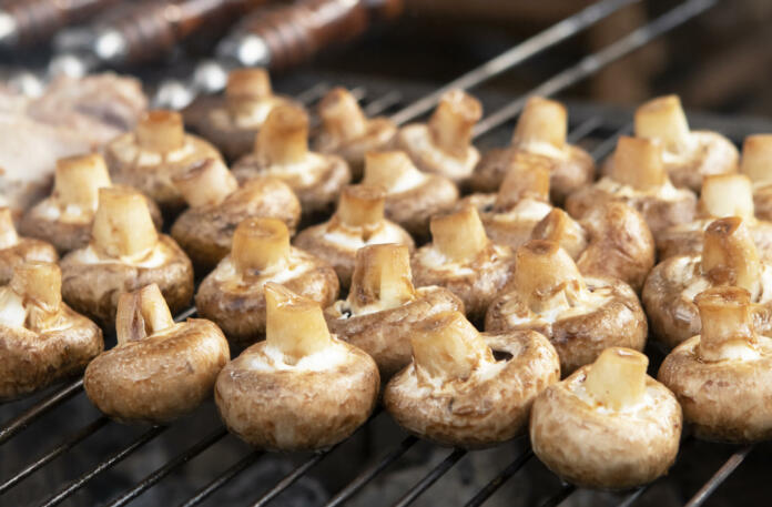 champignon mushrooms are roasted on a barbecue grill