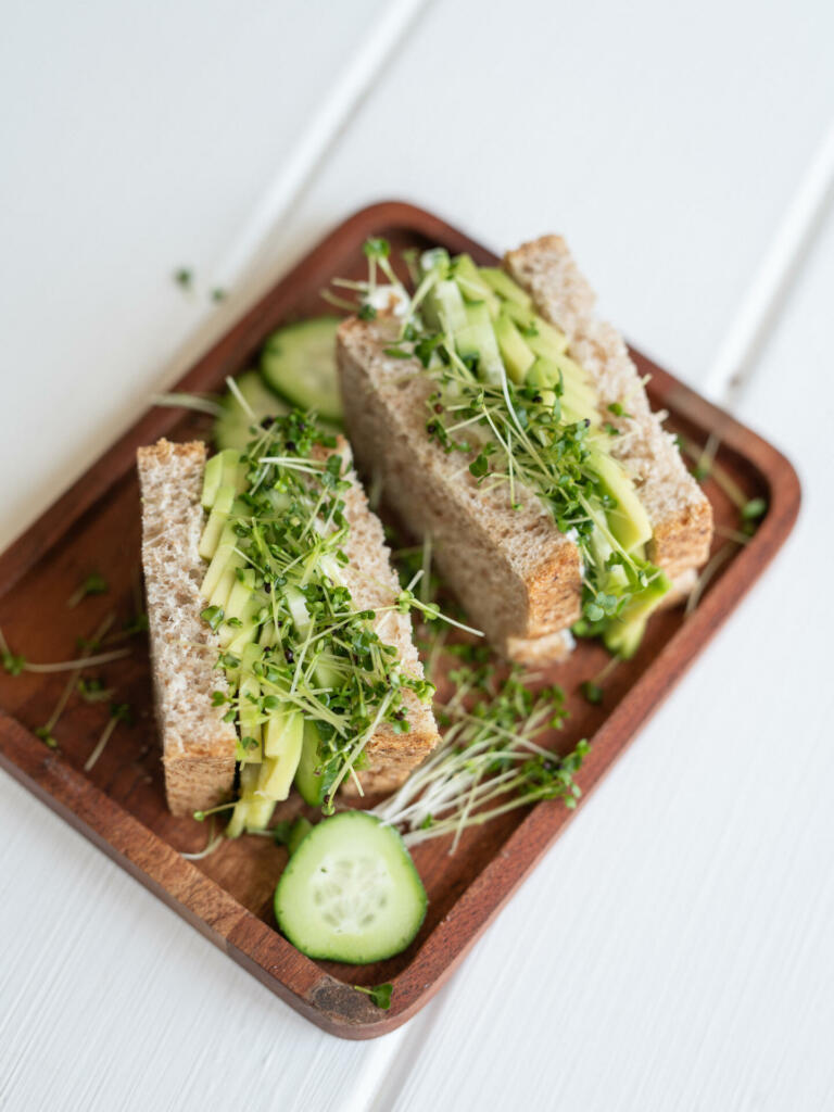 Close up photograph of sandwiches with sprouts and slices of cucumbers