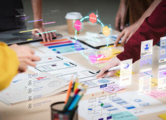 Fakulteta za dizajn s prenovljenim magistrskim programom Vizualne komunikacije in UI/UX Close up ux developer and ui designer use augmented reality brainstorming about mobile app interface wireframe design on desk at modern office.Creative digital development agency