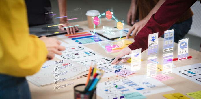 Close up ux developer and ui designer use augmented reality brainstorming about mobile app interface wireframe design on desk at modern office.Creative digital development agency