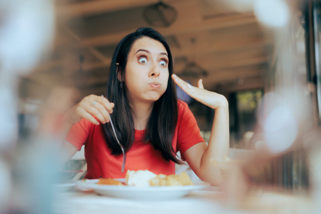 Funny woman hurting from spicey traditional dish course