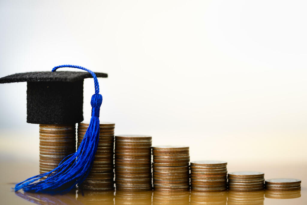 Graduation hat on coins money on white background. Saving money for education or scholarship concepts. Conception of education fee, education expenses, school tuition cost, graduation cap with coin.