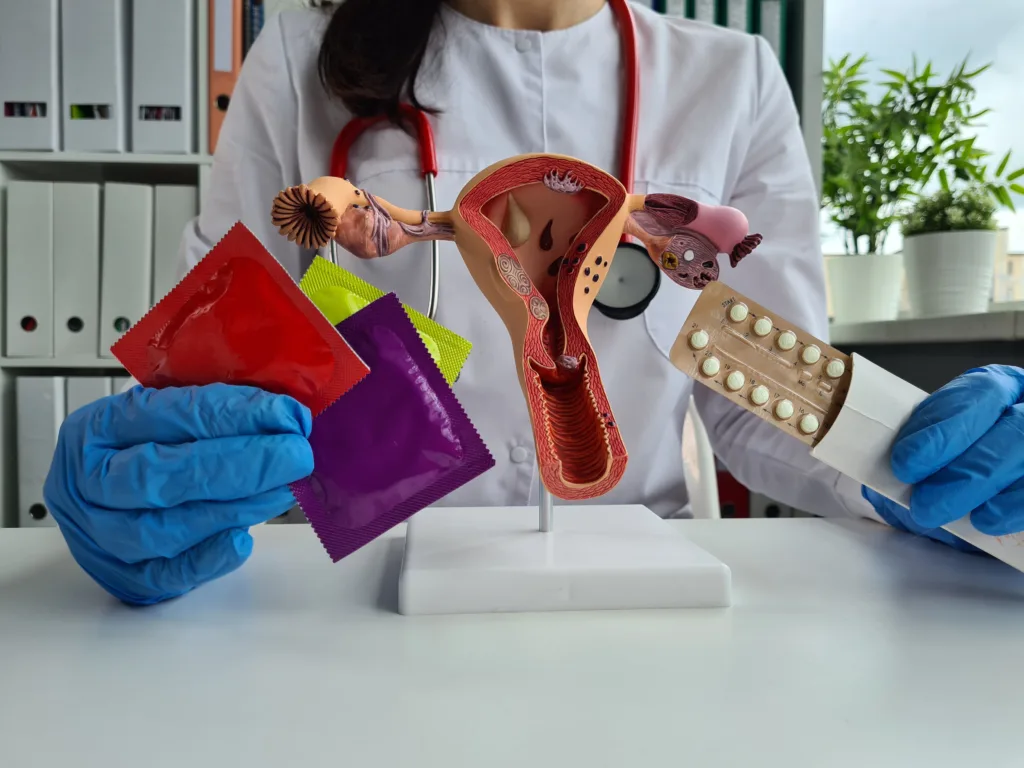 Gynecologist with various contraceptives and uterus. Modern contraception and protection of women health
