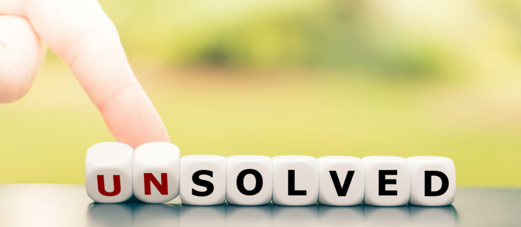 Hand turns dice and changes the word "unsolved" to "solved".